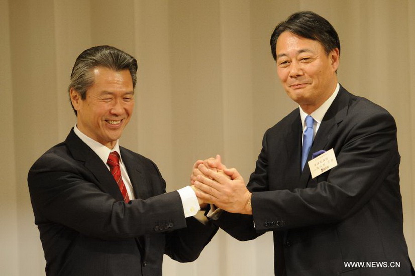Banri Kaieda (R), new leader of the Democratic Party of Japan (DPJ) and former trade minister, shakes hands with former transport minister Sumio Mabuchi before the result of the leadership election of DPJ come out in Tokyo, Dec. 25, 2012. Banri Kaieda on Tuesday became the new leader of the DPJ. (Xinhua/Kenichiro Seki)  