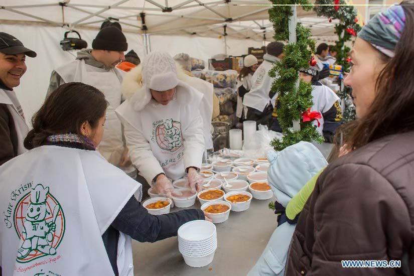 Krishna charity activists distribute free food to people in need in Budapest, Hungary, on Dec. 25, 2012. (Xinhua/Attila Volgyi)