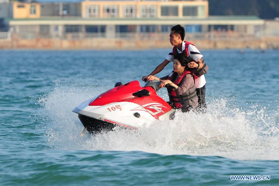 Tourists ride on a motorboat in Sanya, a famous tourism city in south China's Hainan Province, Dec. 25, 2012. Many tourists chose to visit Sanya for its warm weather. (Xinhua/Hou Jiansen)