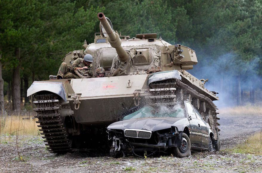 A Canadian drives a tank crushing a car in Christchurch, New Zealand, on Feb 24, 2012. The “Tanks for Everything” company in Christchurch has eight tanks, giving people the chance to real tank working experience and satisfying their weird desires. (Photo/ AFP)