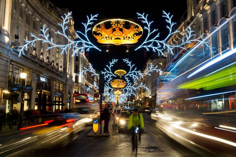 People and vehicles pass through the Christmas decoration on the street in London, Britain, Dec. 14, 2012. (Xinhua/AFP)