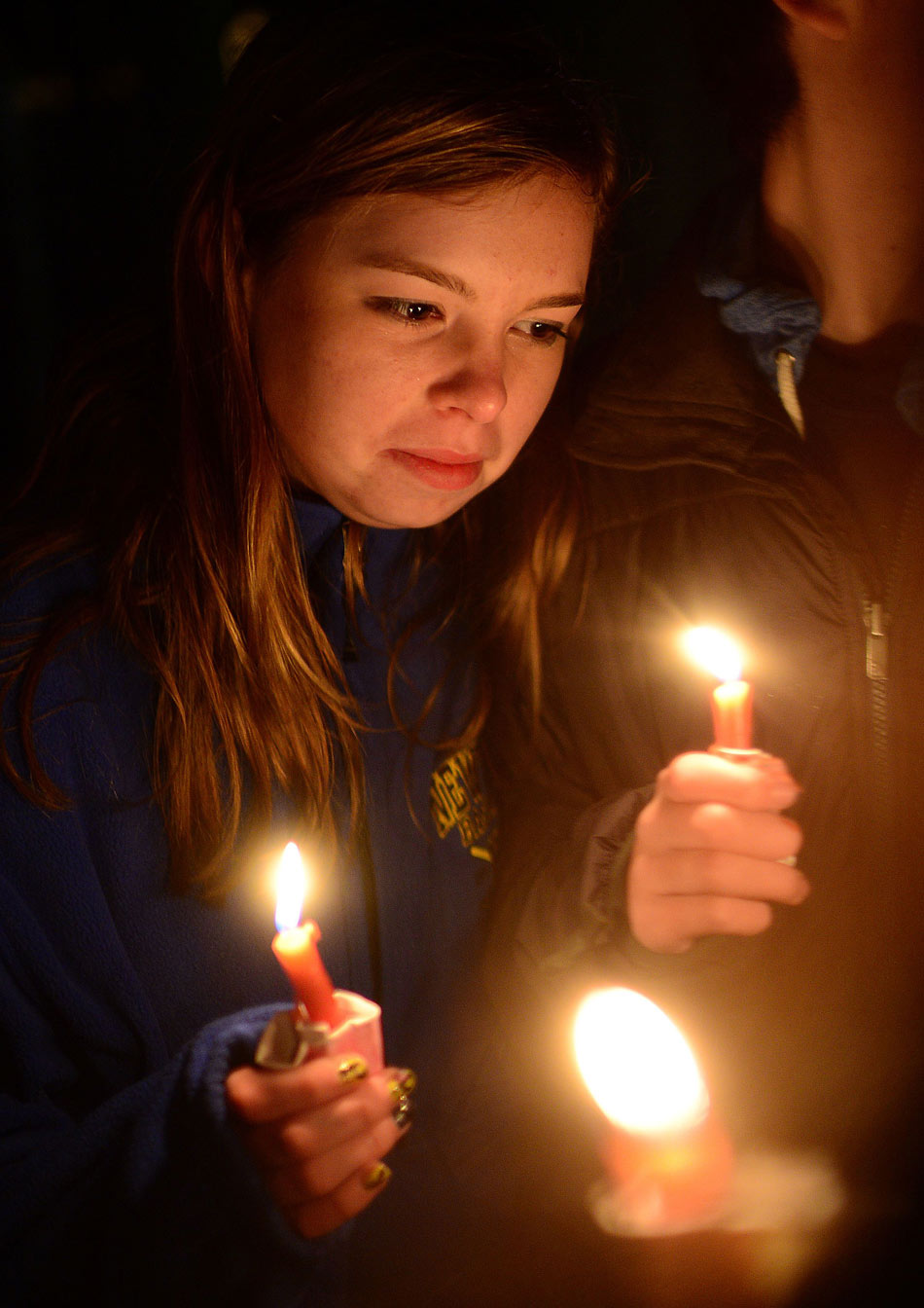 A little girl holds a candle to pay tribute to the victims of the Sandy Hook Elementary School massacre in Connecticut, U.S., Dec. 16, 2012. (Xinhua/AFP)