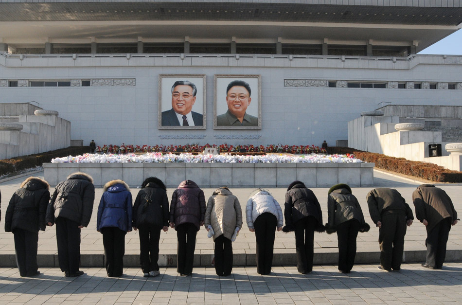 People observe a moment of silence on the Kim Il Sung Square in Pyongyang, Democratic People's Republic of Korea (DPRK) on Dec. 17, 2012 to mark the first anniversary of demise of the late DPRK leader Kim Jong Il. Many people went to the Mansudae in the city centre to present flower baskets and mourn in front of the bronze statues of Kim Il Sung and Kim Jong Il. (Xinhua/Bai Yu)