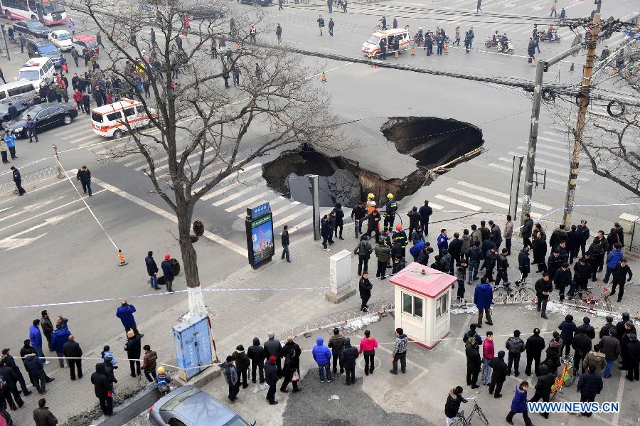 People gather around the collapsed section of a road intersection in Taiyuan, capital of north China' Shanxi Province, Dec. 26, 2012. A hole, measuring around 5 meters deep and 15 meters wide, appeared after the road section collapsed. No casualties were reported by far. (Xinhua/Shi Xiaobo) 