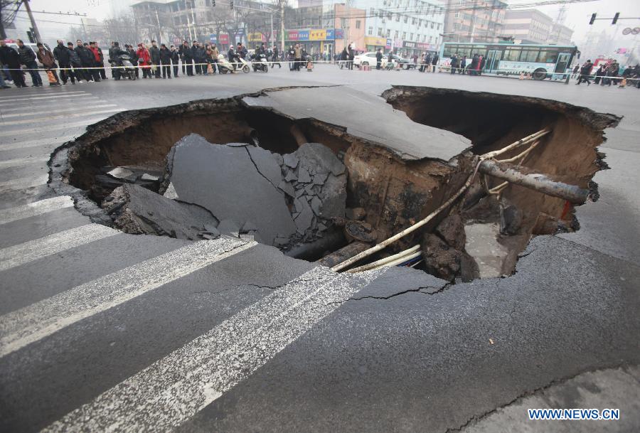 Photo taken on Dec. 26, 2012 shows a collapsed section of a road intersection in Taiyuan, capital of north China' Shanxi Province. A hole, measuring around 5 meters deep and 15 meters wide, appeared after the road section collapsed. No casualties were reported by far. (Xinhua/Shi Xiaobo) 