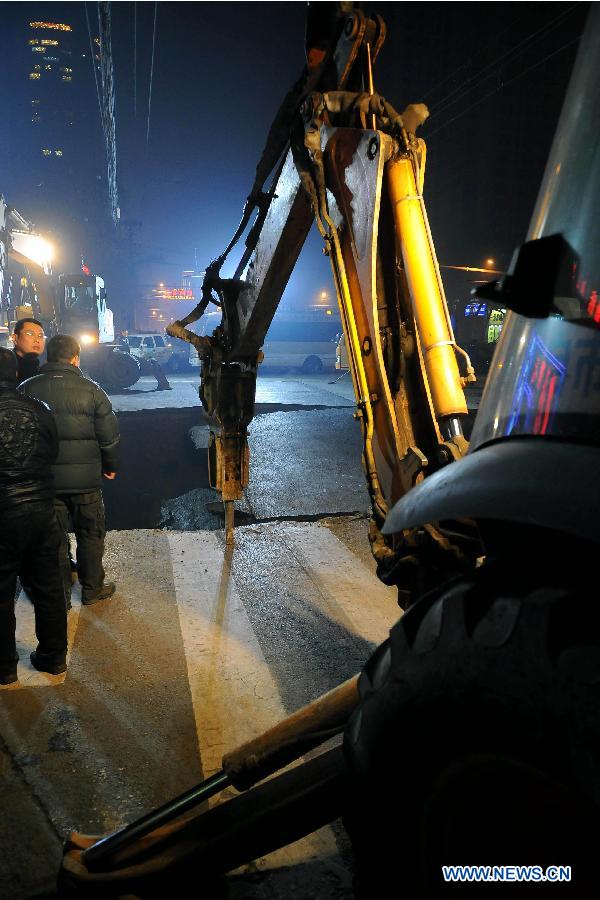 A drilling machine is used to repair the collapsed section of a road intersection in Taiyuan, capital of north China' Shanxi Province, Dec. 26, 2012. The road cave-in happened Wednesday afternnon, leaving a pit measuring around 3 to 4 meters deep, 15 meters long, and 5 meters wide. No casualties were reported. (Xinhua/Fan Minda) 