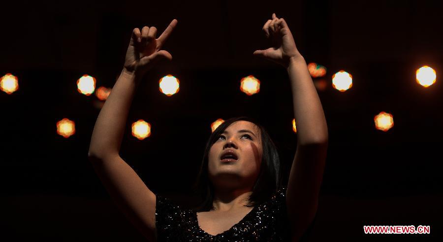 A contestant gives performance during the fifth Hubei Inter-University Sign Language Friendship Competition in Wuhan, capital of central China's Hubei Province, Dec. 25, 2012. The competition, initiated in 2008, aims at promoting sign language knowledge and social awareness among students. (Xinhua/Cheng Min) 