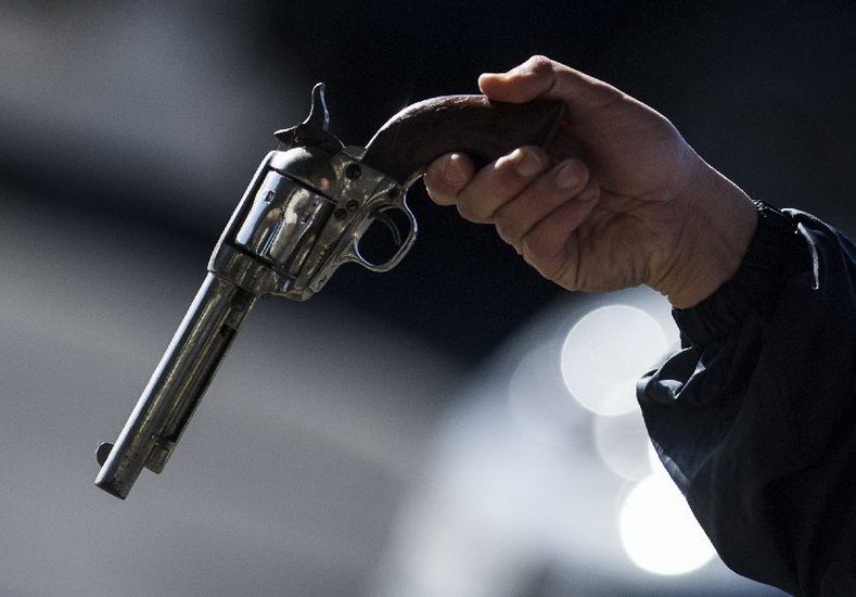 A policeman checks a reclaimed pistol in Los Angeles, the U.S., on Dec. 26, 2012. Los Angeles police reclaimed guns here on Wednesday in response to the Dec. 14 school massacre in Newtown, Connecticut. Locals who handed in their guns could get cash coupon in return. (Xinhua/Yang Lei) 