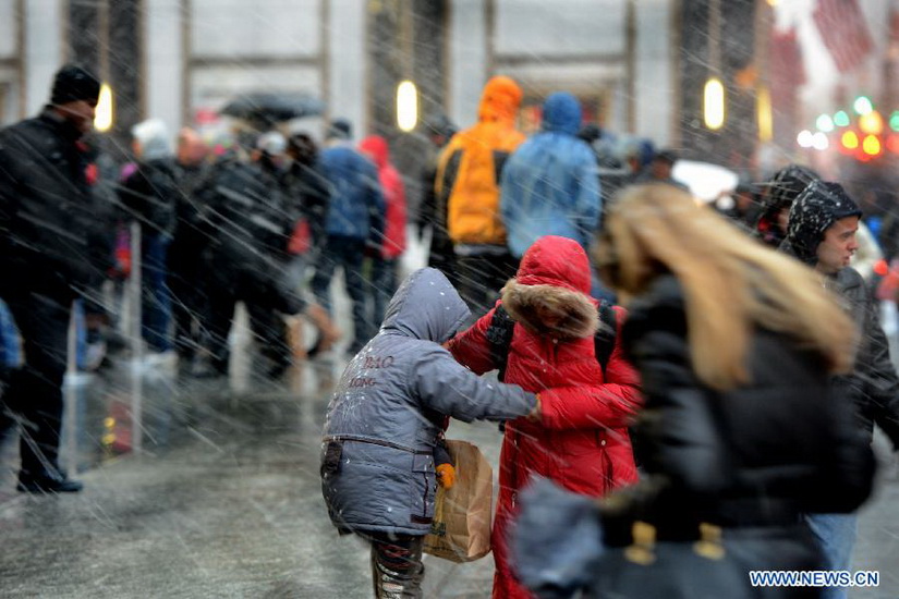 People take cover in a winter storm as snow falls in Manhattan, New York, City on Dec. 26, 2012. The strong storm system that hit the central and southern U.S. on Christmas Day moved to the eastern U.S. on Wednesday, causing flight delays and dangerous road conditions in the Northeast. (Xinhua/Wang Lei) 