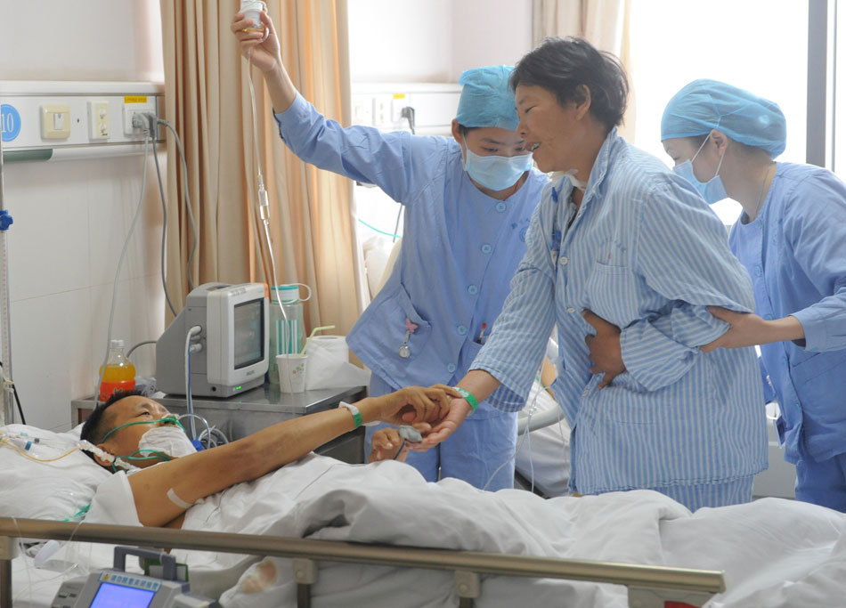 The couple meet each other in tears after 12-hour surgery of living donor liver transplantation in Zhengzhou People’s Hospital, Henan province, on May 13, 2012. The wife named Li Xiuying donated her liver to save her husband from liver cirrhosis. (Photo/Xinhua)