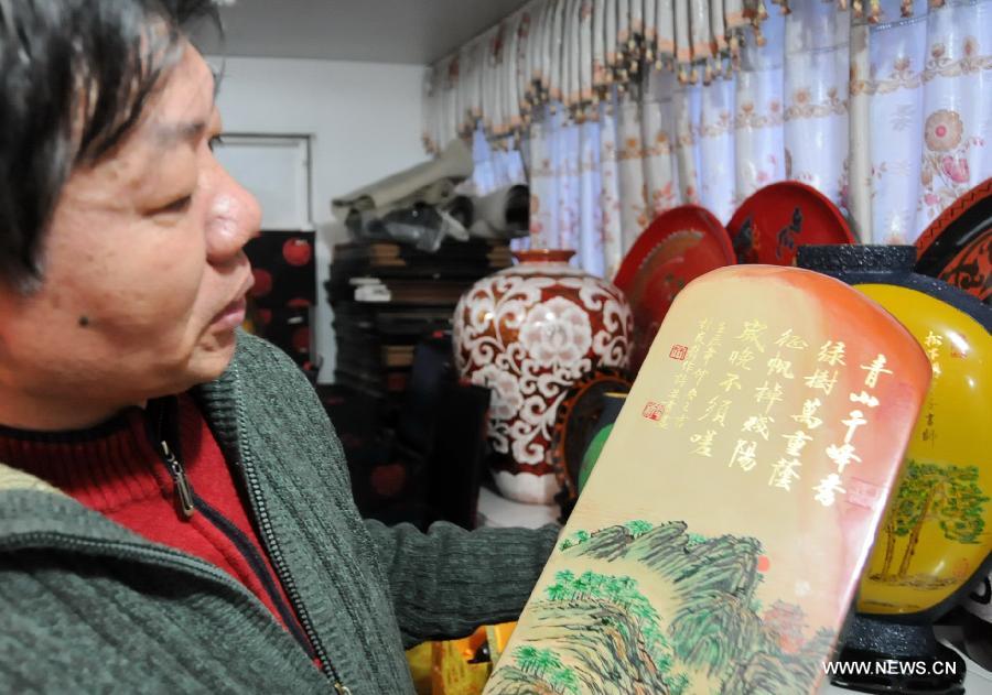 Craftsman Lin Youxin shows a bodiless lacquerware work in Fuzhou, capital of southeast China's Fujian Province, Dec. 26, 2012. (Xinhua/Lin Shanchuan)