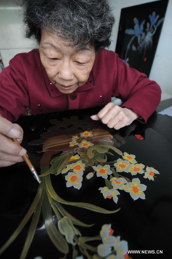 Craftswoman Wu Shouduan make drawings on a bodiless lacquerware in Fuzhou, capital of southeast China's Fujian Province, Dec. 26, 2012. (Xinhua/Lin Shanchuan)