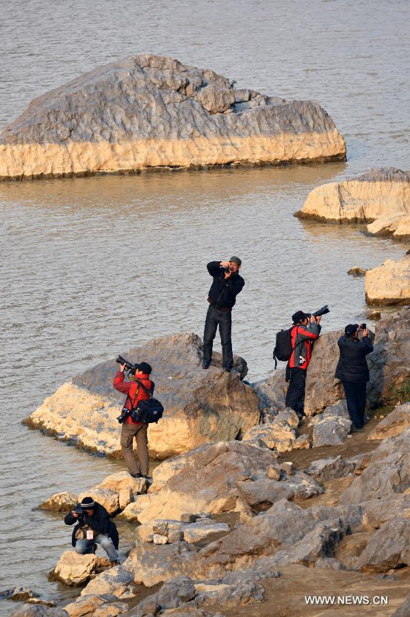 Photography fans take pictures on the bank of the Jialing River, a Yangtze tributary, in the Mingyue Gorge in Guangyuan, southwest China's Sichuan Province, Dec. 26, 2012. (Xinhua/Pan Chaoyue)