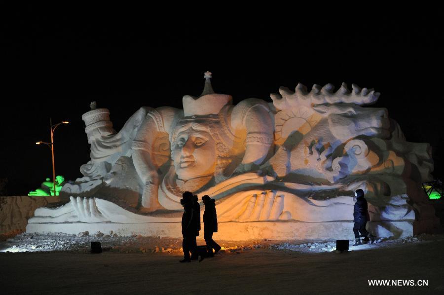 Visitors walk past a snow sculpture in border city Manzhouli in north China's Inner Mongolia Autonomous Region, Dec. 25, 2012. The 14th China, Russia and Mongolia Ice and Snow Sculpture Festival kicked off here on Tuesday. (Xinhua/Asigang)