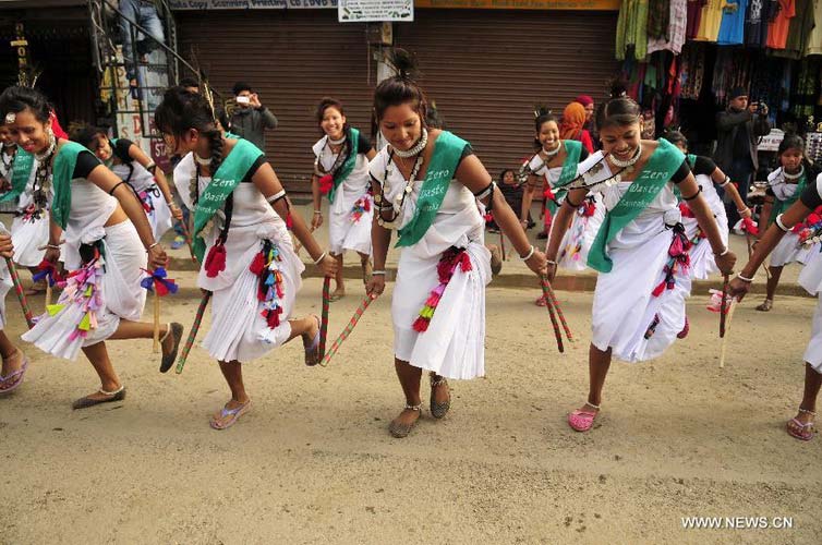Tharu women perform on the opening ceremony of the 9th International Elephant Festival in Sauraha of Chitwan district, Nepal, Dec. 26, 2012. The festival was organized to promote the tourism and to make awareness of elephant conservation in Nepal. (Xinhua/Sunil Pradhan) 