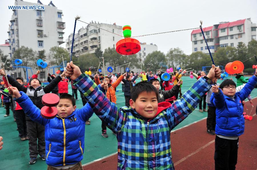 Pupils play traditional Kongzhu, also known as diabolo, at the playground of the Zigui experimental primary school in Zigui County, central China's Hubei Province, Dec. 27, 2012. Kongzhu literarily means empty bamboo, and is one of the major Chinese traditional toys along with shuttlecocks and kites. It is a popular activity among people of various ages. (Xinhua/Wang Huifu)