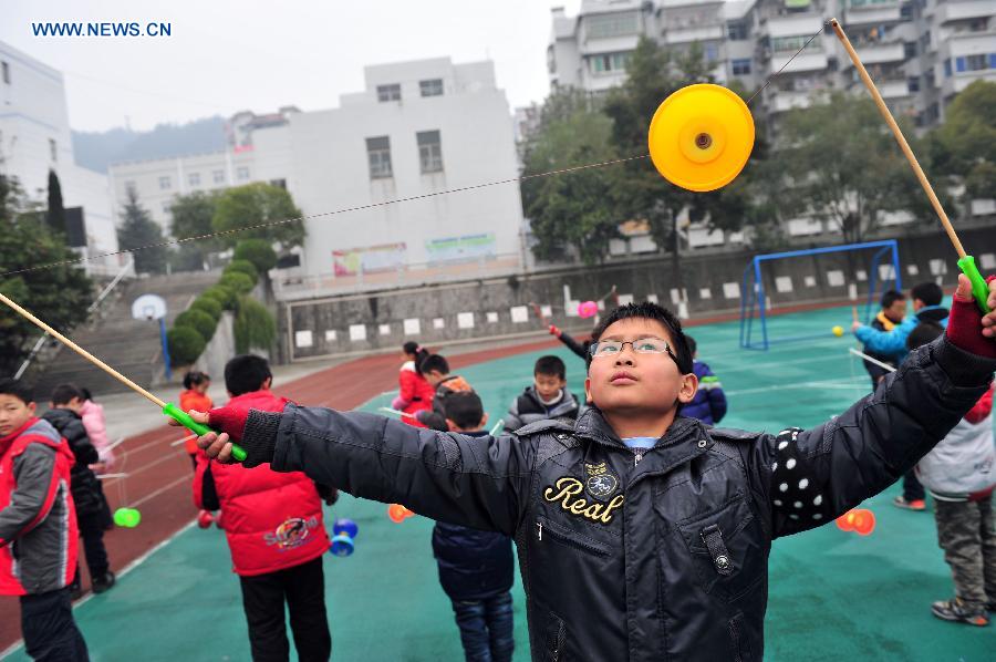 Pupils play traditional Kongzhu, also known as diabolo, at the playground of the Zigui experimental primary school in Zigui County, central China's Hubei Province, Dec. 27, 2012. Kongzhu literarily means empty bamboo, and is one of the major Chinese traditional toys along with shuttlecocks and kites. It is a popular activity among people of various ages. (Xinhua/Wang Huifu)