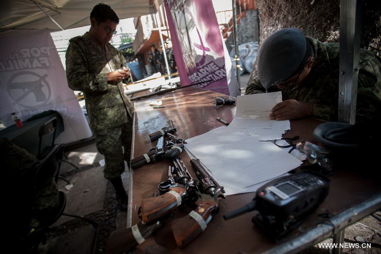 A Mexican Army soldier fills in a registeration form of weapons, which are exchanged for groceries and cash by residents as part of "For your family, voluntary disarmament" program held at Iztapalapa Deputation, in Mexico City, capital of Mexico, on Dec. 27, 2012. (Xinhua/Pedro Mera)