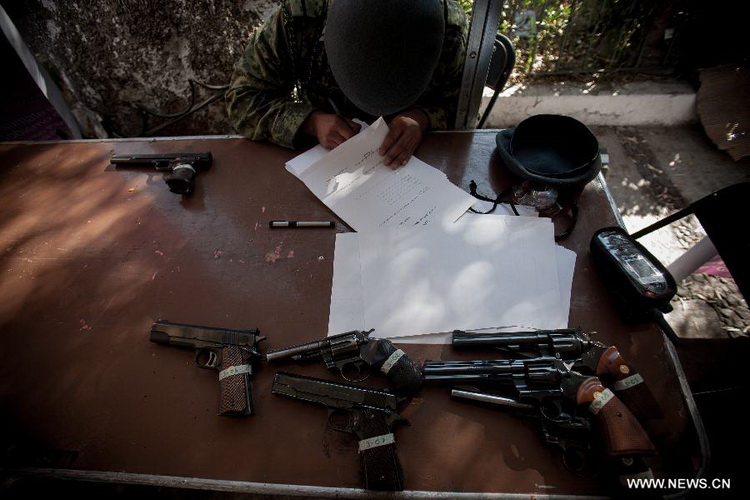 A Mexican Army soldier fills in a registeration form of weapons, which are exchanged for groceries and cash by residents as part of "For your family, voluntary disarmament" program held at Iztapalapa Deputation, in Mexico City, capital of Mexico, on Dec. 27, 2012. (Xinhua/Pedro Mera) 