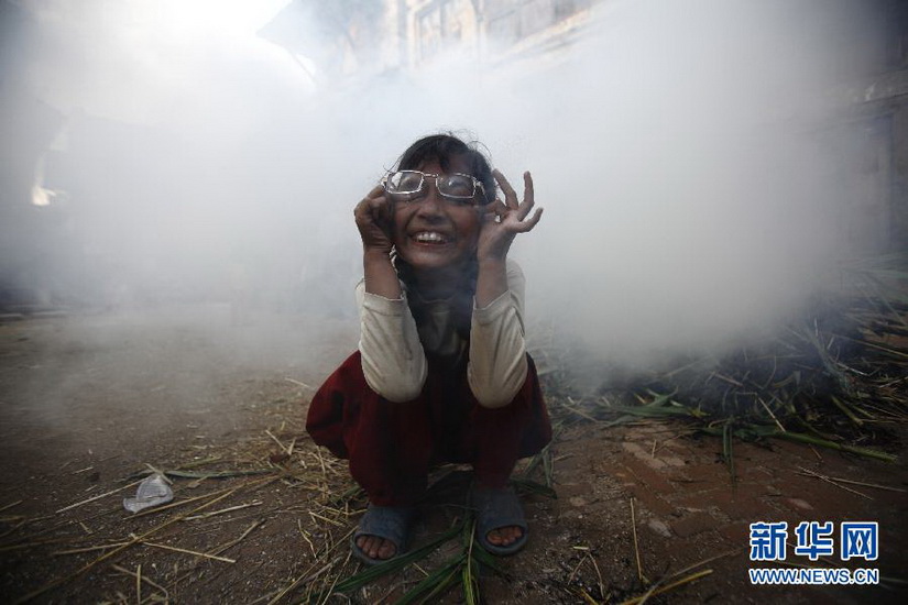 A girl rubs her eyes as smoke rises from a burning effigy of the demon Ghantakarna, symbolizing the destruction of evil, during the “Ghantakarna festival” in Bhaktapur, Nepal on July 17, 2012. According to legend, the demon is believed to ''steal'' children and women from their homes. (Xinhua/Reuters Photo)