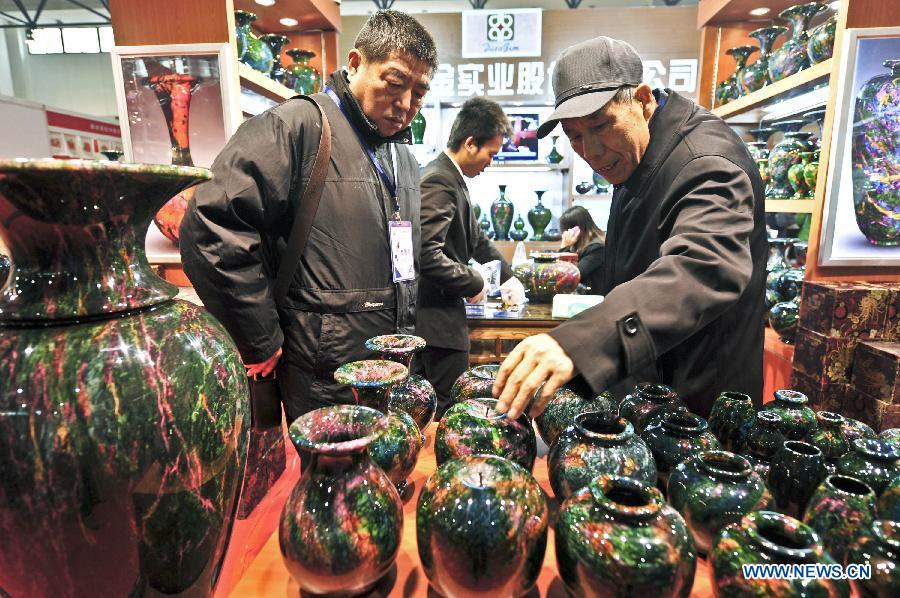 Two visitors look at multi-coloured marble craftworks at the 2012 Beijing Tourism Product Expo in Beijing, capital of China, Dec. 28, 2012. The four-day expo was opened Friday at the China International Exhibition Center in Beijing. Tourism souvenirs, craftworks, business gifts, outdoor gears and cultural and creative products from about 1,000 exhibitors were demonstrated at the event. (Xinhua/Wang Jingsheng)