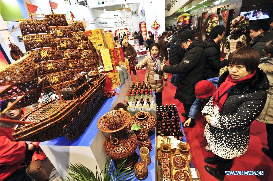 Visitors stop by a vinegar dealer at the 2012 Beijing Tourism Product Expo in Beijing, capital of China, Dec. 28, 2012. The four-day expo was opened Friday at the China International Exhibition Center in Beijing. Tourism souvenirs, craftworks, business gifts, outdoor gears and cultural and creative products from about 1,000 exhibitors were demonstrated at the event. (Xinhua/Wang Jingsheng)