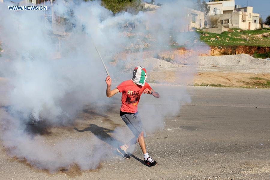 A Palestinian protester throws stones at Israeli soldiers during a protest against the expanding of Jewish settlement in the West Bank village of Nabi Saleh, near Ramallah, on Dec. 28, 2012. (Xinhua/Fadi Arouri) 