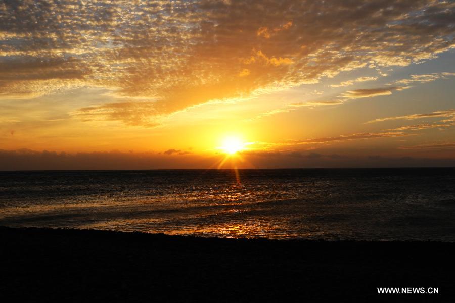 Photo taken on Dec. 27, 2012 shows the sunset scene in Kenting Park in Pingtung County, southeast China's Taiwan. At the southernmost end of Taiwan island, Kenting Park is surrounded by water on three sides. It faces the Pacific in the east, the Taiwan Strait in the west and the Bashi Channel in the south. (Xinhua/Xing Guangli)