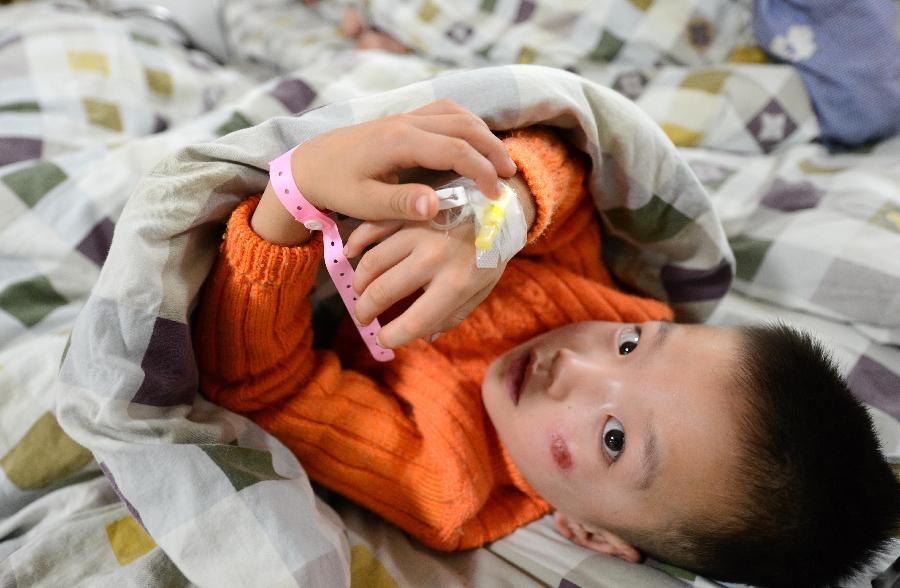 An injured child receives treatment at the People's Hospital in Guixi, east China's Jiangxi province, Dec. 24, 2012.Four kindergarten children who were trapped in a van which overturned and fell into a pond on Monday have been rescued. A total of 17 people including 15 kingdergarten children were in the van when the accident occurred. Three children were killed on the spot, and eight others died later in a hospital after rescue efforts failed. (Xinhua/Zhou Ke)