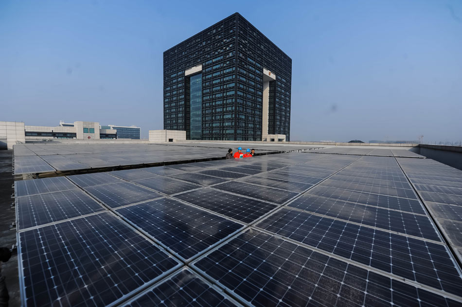 Staffs of Huzhou Electric Power Bureau check the solar photovoltaic panels which have just been put in use on Dec. 24, 2012.With the joint efforts of Huzhou Electric Power Bureau and the government of Nanxun district of Huzhou city, Huzhou’s first solar rooftop power project has been realized. (Xinhua/Xu Yu)