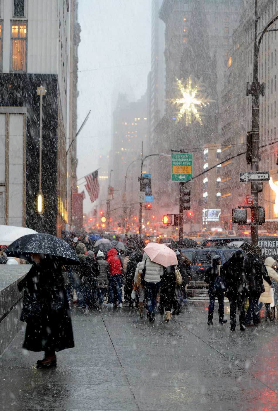 People walk through the Fifth Avenue in heavy snow in New York, U.S., Dec. 26, 2012. According to American National Weather Service, a strong snowstorm was moving from the south to the east, which caused flights delay and traffic block in New York, Ohio and several east west cities. (Xinhua/Wang Lei)