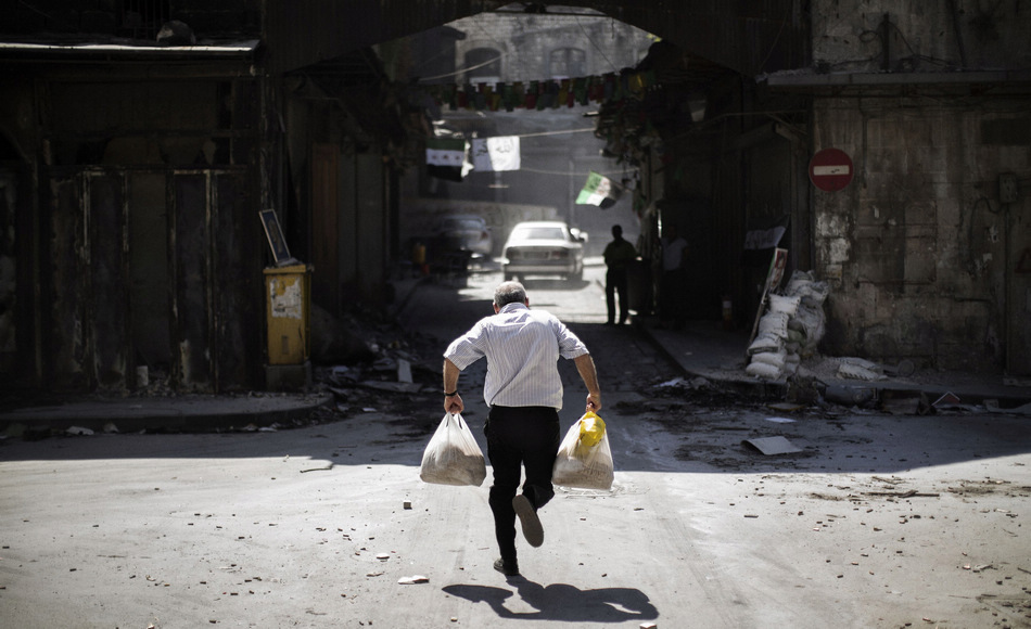 A man carries a bag to escape the crossfire in Syria’s northern city of Aleppo on Sept. 12, 2012. (Xinhua/AFP)