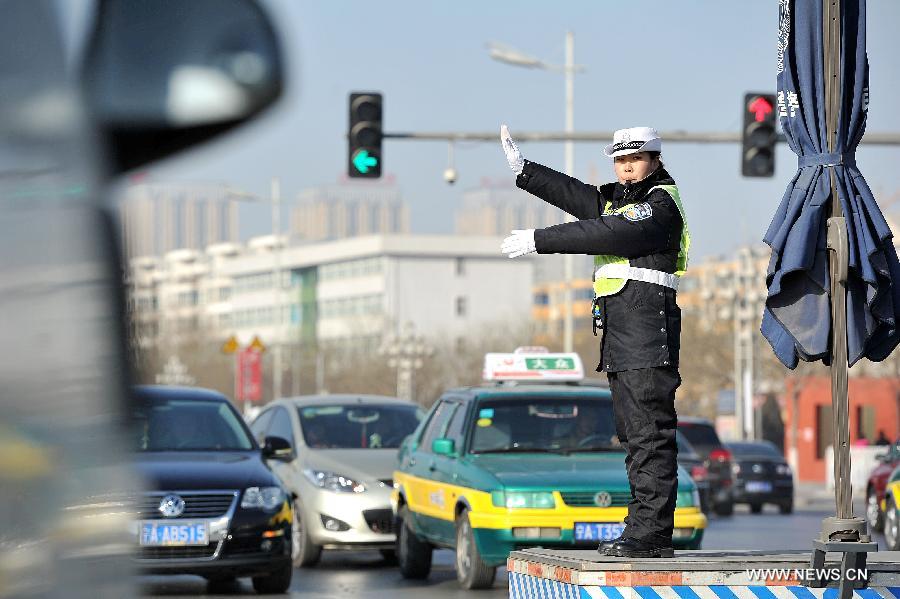A policewoman directs the traffic at an intersection in Chuancheng District of Yinchuan City, capital of northwest China's Ningxia Hui Autonomous Region, Jan. 1, 2013. The revised traffic regulation takes effect on Tuesday. According to the new rules, 52 different sorts of violations can result in deducting points for punishment, up from 38 under the previous regulation. (Xinhua/Peng Zhaozhi) 
