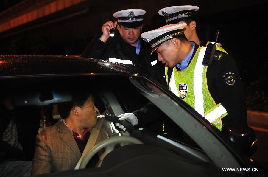 A driver takes an alcohol test in Shenzhen, south China's Guangdong Province, Jan. 1, 2013. The revised traffic regulation takes effect on Tuesday. According the new rules, 52 different sorts of violations can result in deducting points for punishment, up from 38 under the previous regulation. (Xinhua/Liang Xu) 