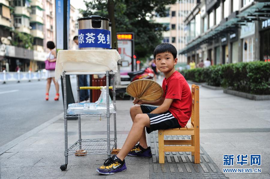 Growth is achieved by kindness: Ruan Tianjie waits for passers-by who may take his free herbal tea in Hanzhou, Zhejiang province. Only 10-year-old, Ruan has handed out free tea for thirsty people in hot summer days for three years. Ruan said his herbal tea stall will sustain till he finishes the elementary school education. (Xinhua/Ju Huanzong)