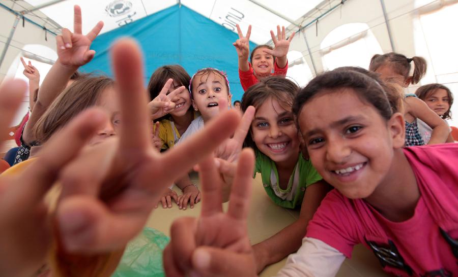 Syrian refugee children pose during their fourth day of school at Al Zaatri refugee camp in the Jordanian city of Mafraq, near the border with Syria, Oct. 4, 2012. The school is granted by the EU to provide education to Syrian refugees residing in Jordan. (Xinhua/Mohammad Abu Ghosh)
