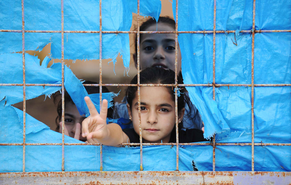Syrian refugee children look on from a tent at the Yayladagi refugee camp in Hatay province, Turkey, on Oct. 17, 2012. The number of Syrian refugees in Turkey reaches 100,363, as announced by the Turkish government on Monday. (Ma Yan/Xinhua) 