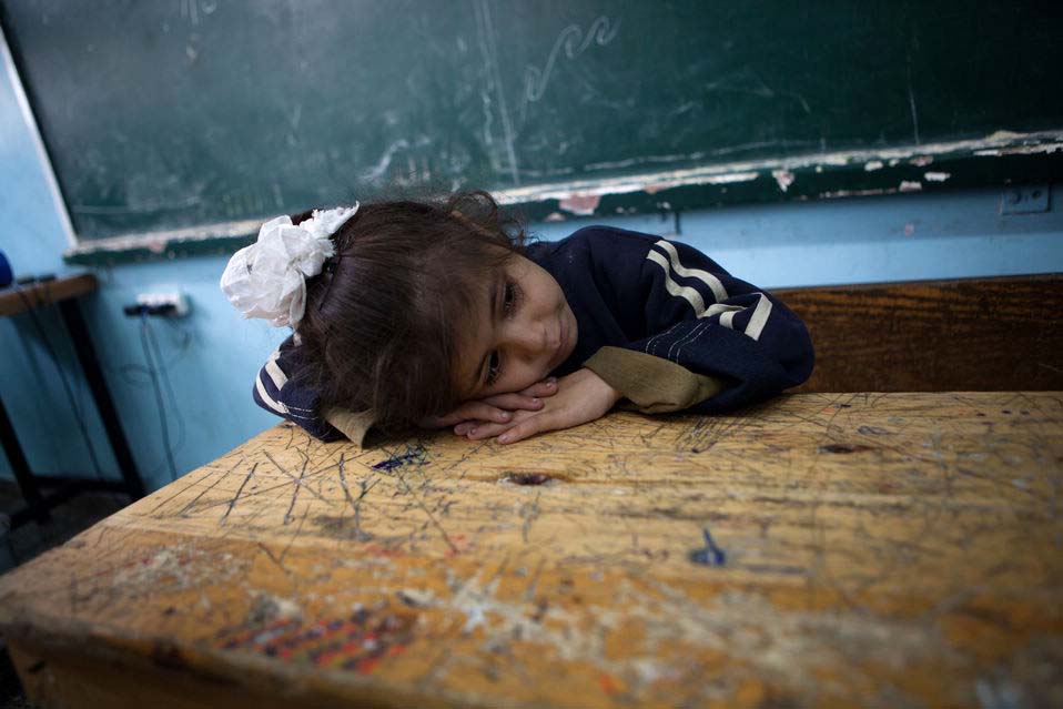 A girl with tears in her eyes is having a rest at a U.N. school in Gaza on Nov. 21, 2012. Israeli air force on Tuesday attacked the northern and northeastern areas of the Gaza Strip where they dispatched leaflets in Arabic to local residents by airplane, telling them to leave their home and flee for their lives. (Xinhua/Chen Xu)