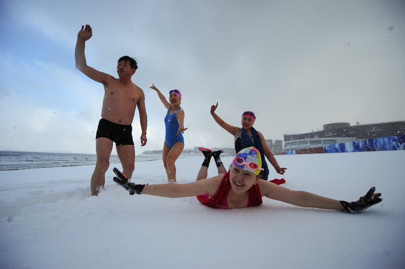 Winter swimmers do the warm-up exercise on snow in Yantai, east China's Shandong Province, Jan. 2, 2013. Over 200 local citizens swam in the sea on Wednesday to welcome the new year. (Xinhua/Chu Yang) 