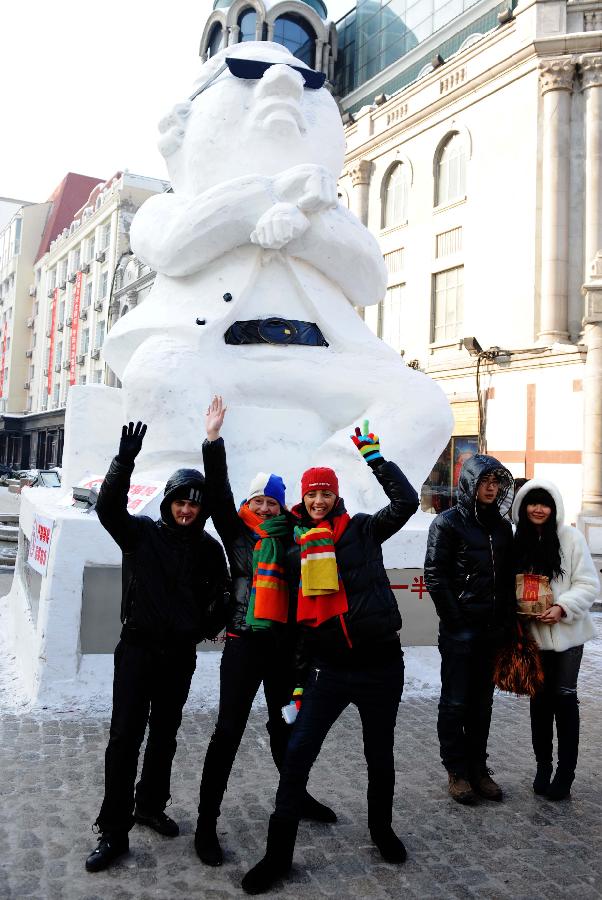 Tourists pose for photo in front of a snow sculpture of South Korean rapper Psy in Harbin, capital of northeast China's Heilongjiang Province, Jan. 2, 2013. Psy's music video of "Gangnam Style," featuring the horse-riding dance, became a global sensation this year. (Xinhua/Wang Jianwei) 