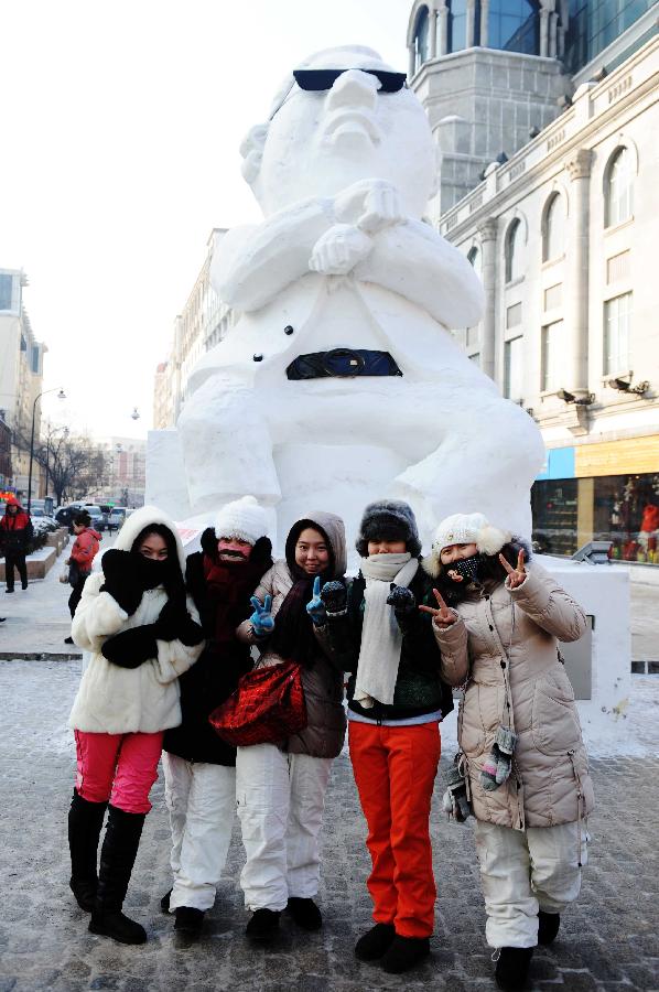 Tourists pose for photo in front of a snow sculpture of South Korean rapper Psy in Harbin, capital of northeast China's Heilongjiang Province, Jan. 2, 2013. Psy's music video of "Gangnam Style," featuring the horse-riding dance, became a global sensation this year. (Xinhua/Wang Jianwei)