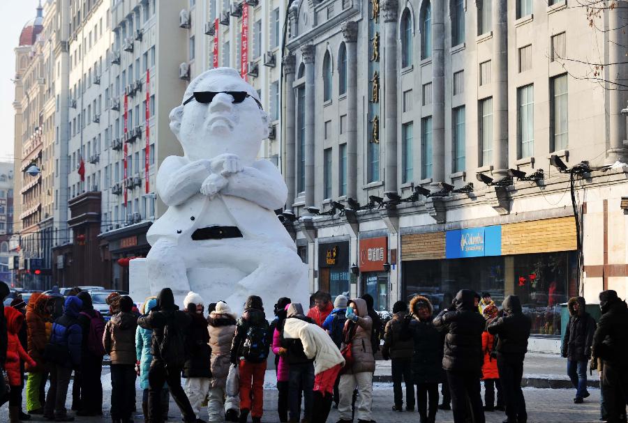 Tourists gather in front of a snow sculpture of South Korean rapper Psy in Harbin, capital of northeast China's Heilongjiang Province, Jan. 2, 2013. Psy's music video of "Gangnam Style," featuring the horse-riding dance, became a global sensation this year. (Xinhua/Wang Jianwei)