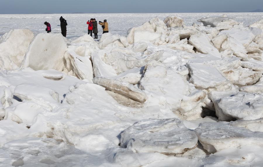 Tourists visit an ice-covered beach in Dalian, northeast China's Liaoning Province. Sea ice continues to occur in some Chinese coastal provinces as a result of recent cold waves. (Xinhua/Xu Dewu)