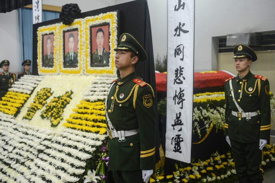 Soldiers stand straight at the memorial meeting for the deceased firefighters who lost lives in a rescue operation on Jan. 1 at the Hangzhou Yusei Machinery Co., Ltd in Hangzhou, capital of east China's Zhejiang Province, Jan. 4, 2013. (Xinhua/Han Chuanhao) 