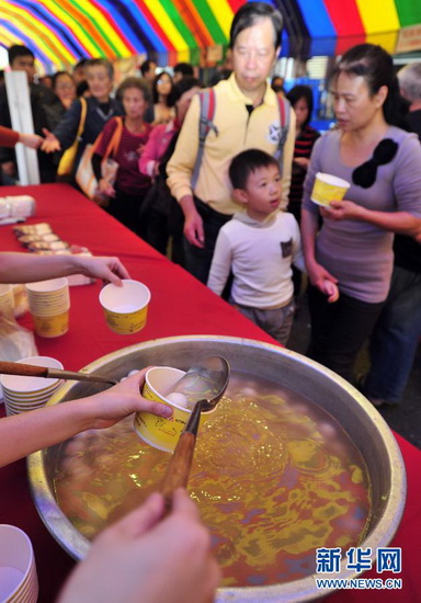 Having Tangyuan to greet the winter solstice： People wait in queue to get free Tangyuan (Glutinous Rice Balls) on Dec. 15, 2012. To greet the winter solstice, Taipei Yansan Business district and Flora expo Yuan-shan Park hold activities to make and taste Tangyuan. (Xinhua/Wu Jingteng)