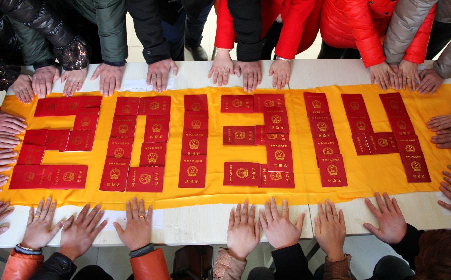 Couples pray before a number "201314" shaped by marriage certificates at the marriage registration office in Zaozhuang, east China's Shandong Province, Jan. 4, 2013. Many couples here flocked to tie the knot on Jan. 4, 2013, or 2013/1/4, which sounds like "Love you forever" in Chinese. (Xinhua/Sun Zhongzhe)