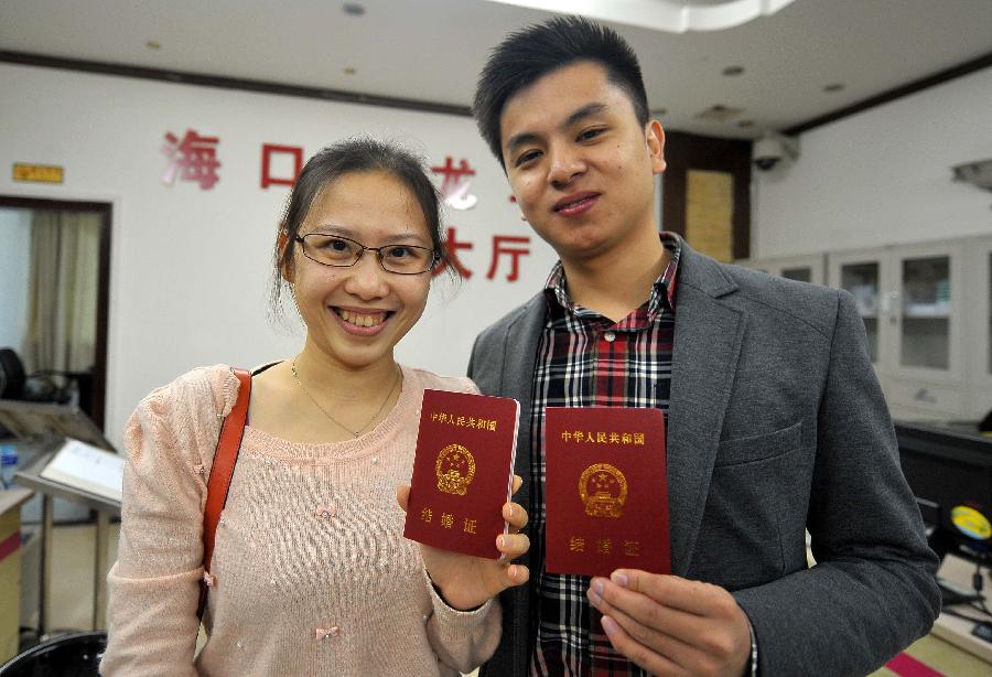 A couple show their marriage certificates at the marriage registration office in Haikou, capital of south China's Hainan Province, Jan. 4, 2013. Quite a number of couples flocked to tie the knot on Jan. 4, 2013, or 2013/1/4, which sounds like "Love you forever" in Chinese. (Xinhua/Guo Cheng)