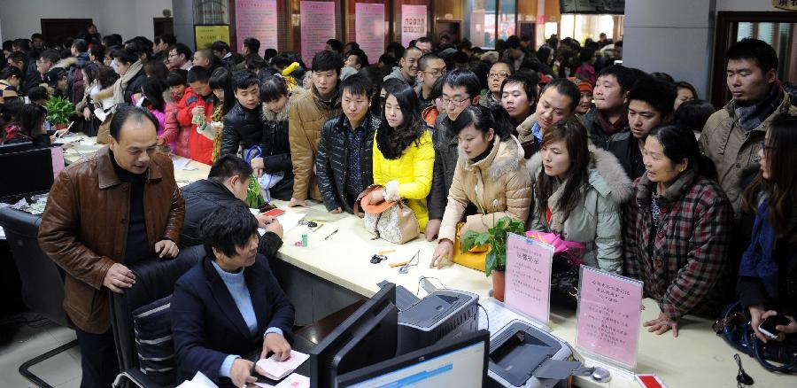 Couples crowd the marriage registration office in Zhengzhou, capital of central China's Henan Province, Jan. 4, 2013. Quite a number of couples flocked to tie the knot on Jan. 4, 2013, or 2013/1/4, which sounds like "Love you forever" in Chinese. (Xinhua/Li Bo)