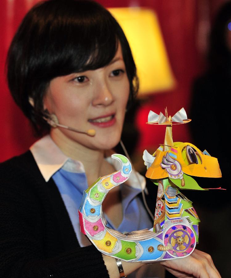 The designer of the small hand lantern shows the lantern featuring a cartoon snake during a news conference at the Grand Hotel in Taipei, southeast China's Taiwan, Jan. 4, 2013. The conference held on Friday was to issue the shapes of the main lantern and small hand lantern of 2013 Taiwan Lantern Festival. The festival will kick off in Taipei on Feb. 24. (Xinhua/Wu Ching-teng)