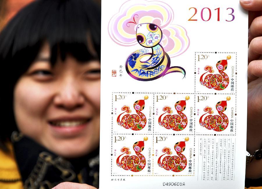 A staff member shows a smaller-size page of "year of snake" stamps at Handan Post Office in Handan, north China's Hebei Province, Jan. 4, 2013. The lunar year 2013 is the "Year of the Snake" in the Chinese zodiac. The stamp of "year of snake" will be released by China Post on Jan. 5. (Xinhua/Hao Qunying)